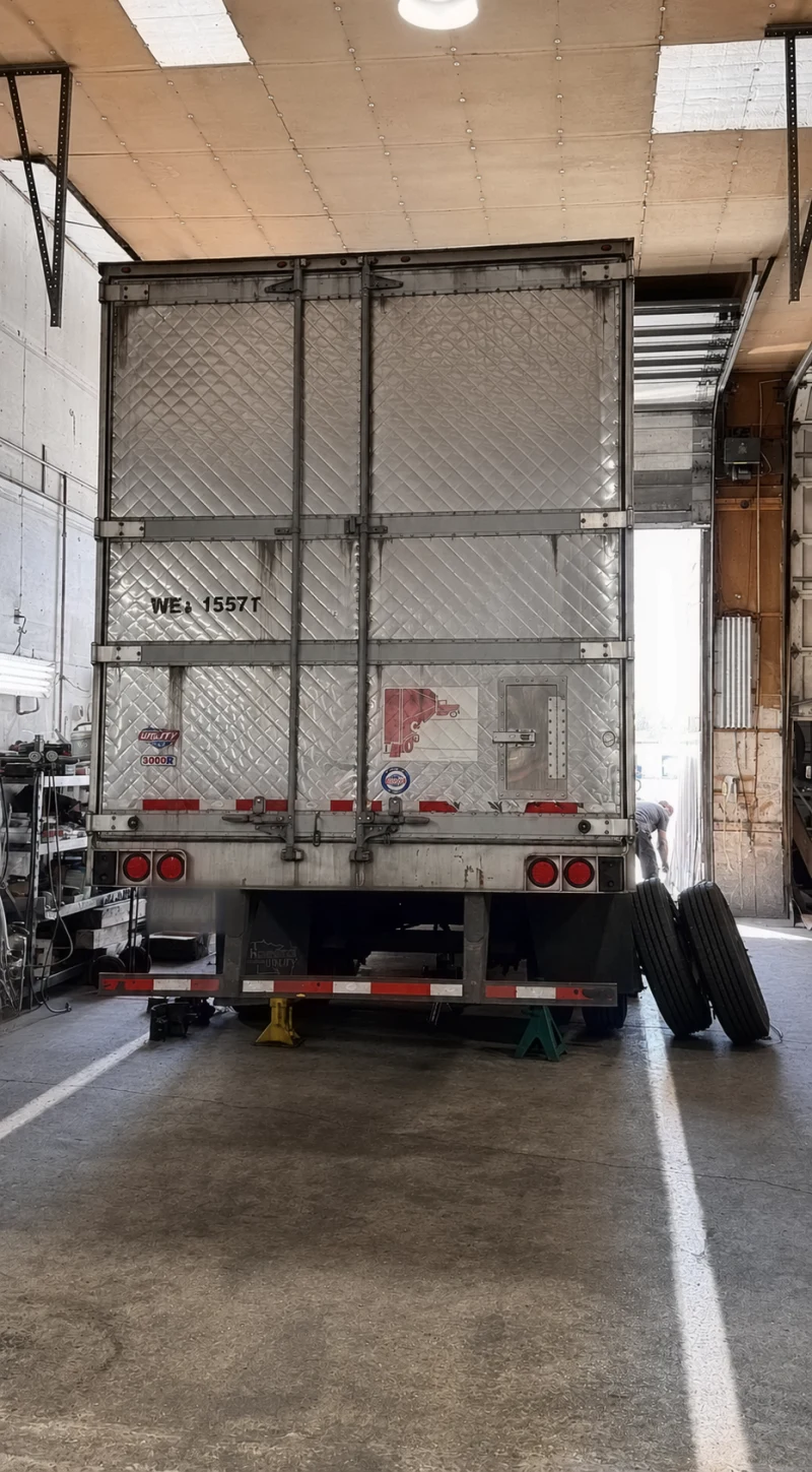 Heavy-duty trailer supported on jack stands with wheels removed for service at Big Truck & Trailer Repair in Park City, Illinois